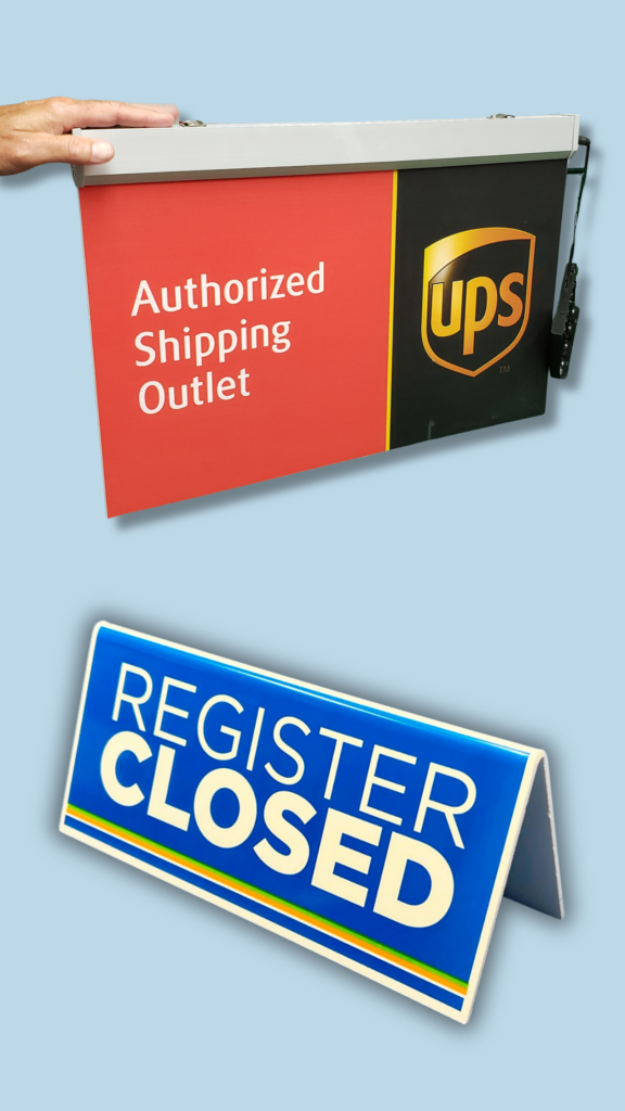 UPS and Register Closed Sign | BAW Plastics Inc. | BAW Plastics Inc. Panel sign reads 'Authorized Shipping Outlet' next to a UPS logo, held by a hand against a blue background. A blue 'Registered Closed' sign is tilted nearby.