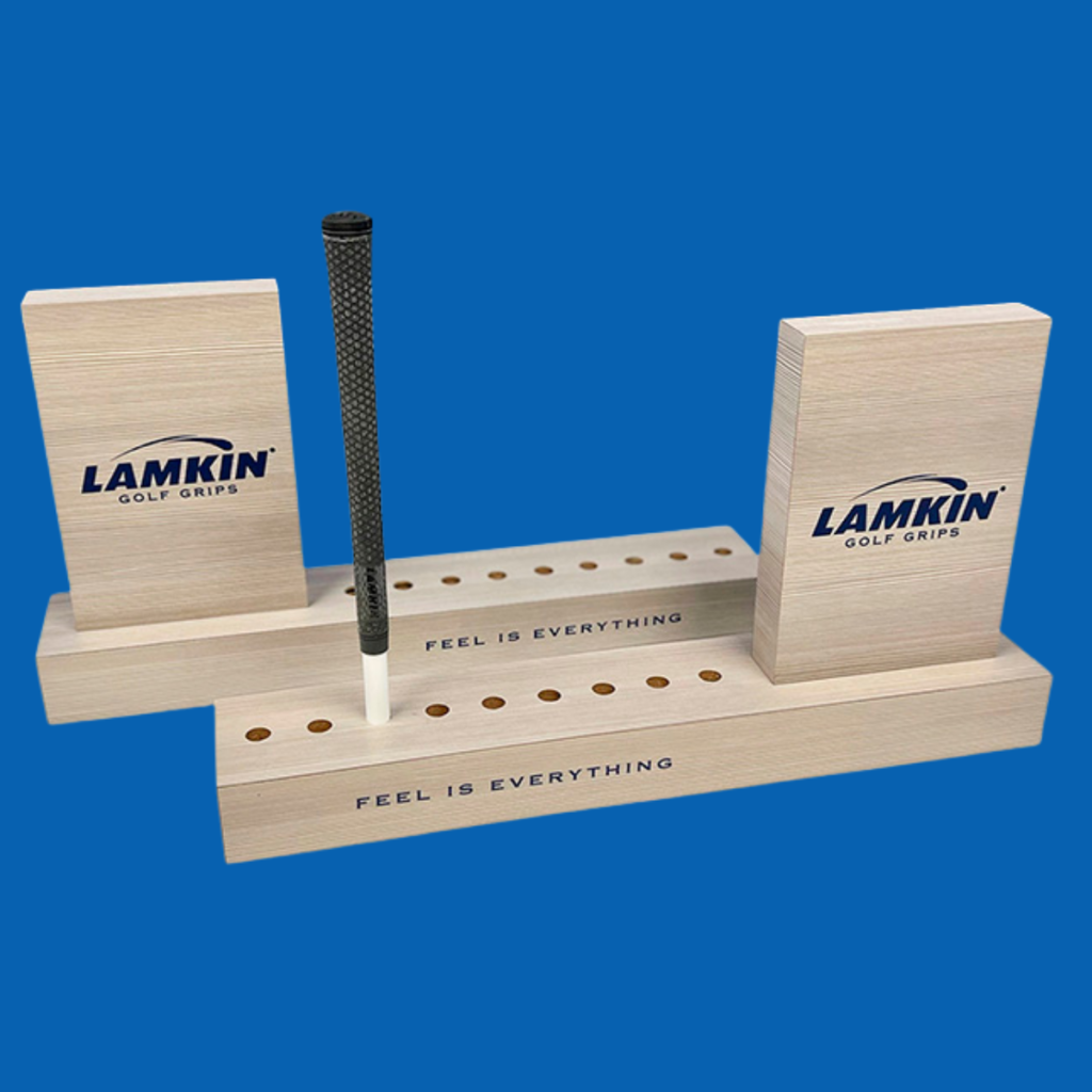 Lamkin Golf Grip Display | BAW Plastics Inc. | BAW Plastics Inc. Lamkin golf grip display with two wooden blocks and a single black grip between them, the slogan 'Feel is Everything' visible.