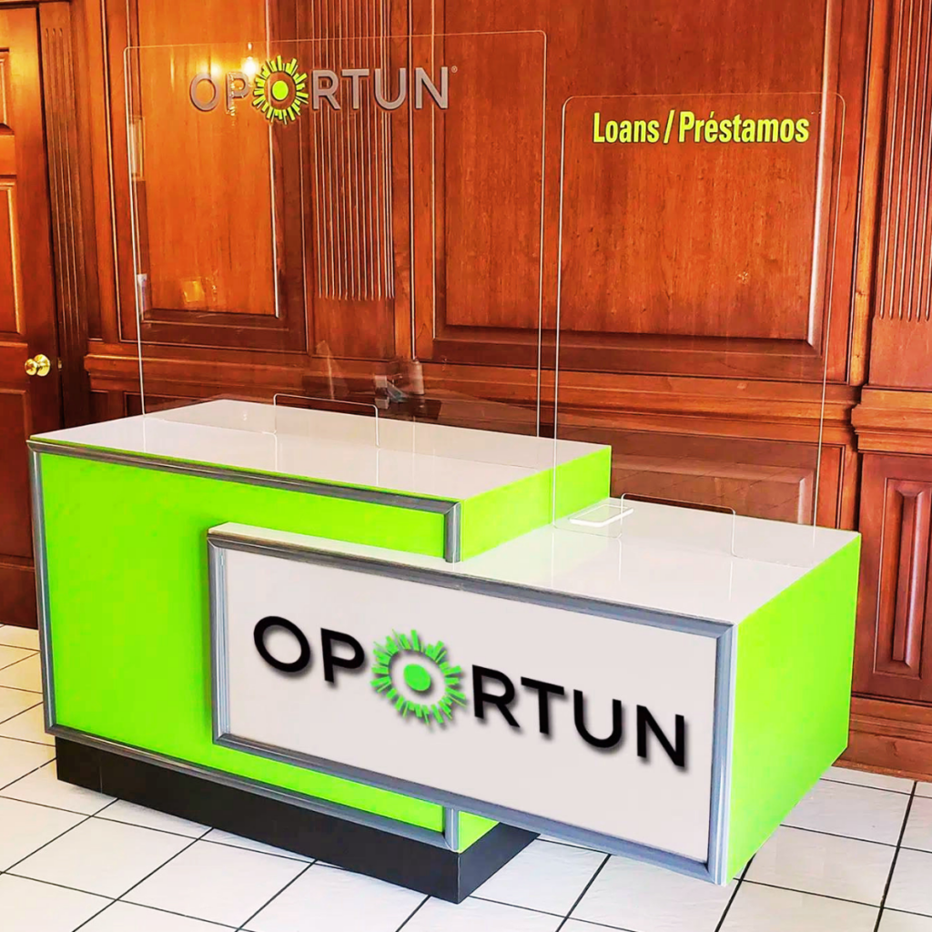 Oportun Front Counter | BAW Plastics Inc. | BAW Plastics Inc. Bright lime-green loan desk with clear acrylic dividers, branded with the word OPORTUN and a sun logo, and a Loans/Préstamos sign nearby.